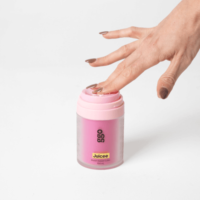 Hand pressing top of Juicee 100ml water-based lube bottle by Girls Get Off – hygienic pump dispenser design for easy, mess-free use.