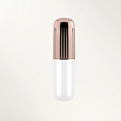 A hand holding a white and rose gold Satisfyer Secret Affair lipstick bullet vibrator against a plain background.