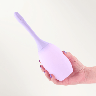 A hand holding INYA Refresh  on an off-white background