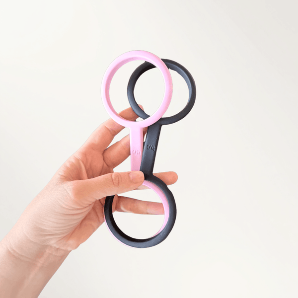 Hand holding pink and black luff cuffs